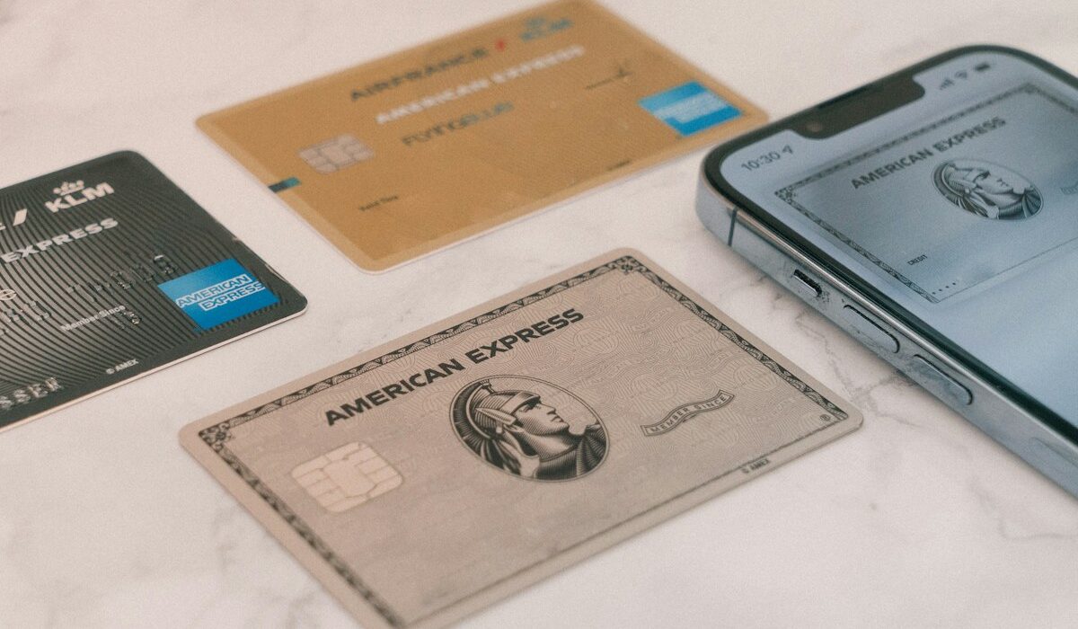 American Express credit cards beside a smartphone illustrating the American Express AML penalty