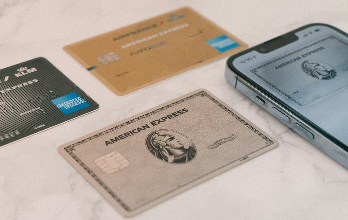 American Express credit cards beside a smartphone illustrating the American Express AML penalty