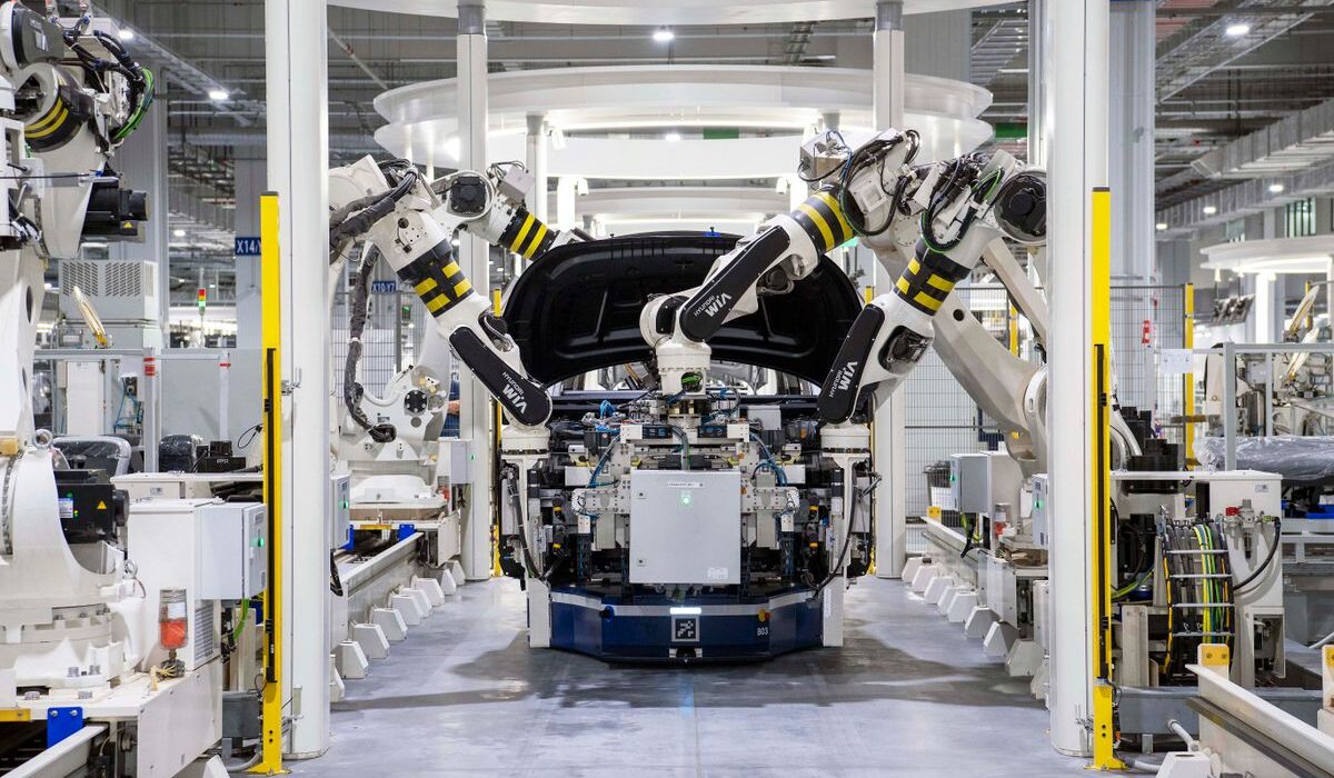 Automotive factory robots assembling a vehicle body ahead of Ford earnings