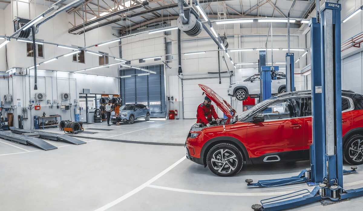 Mechanics servicing vehicles inside an automotive repair workshop