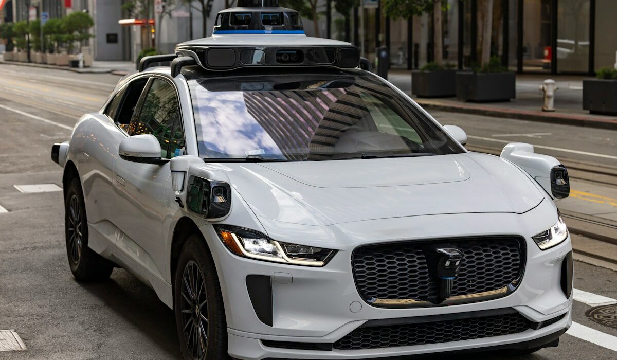 White autonomous vehicle operating on an urban road