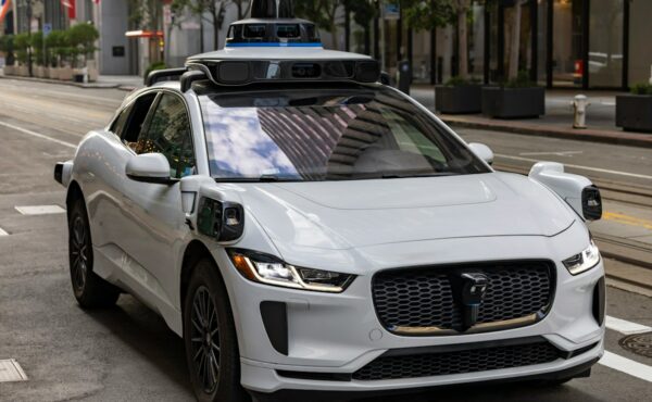 White autonomous vehicle operating on an urban road