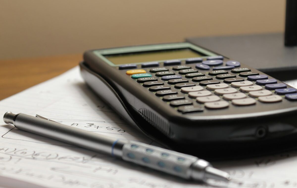 Book value per share calculation with a calculator, pen and financial notes