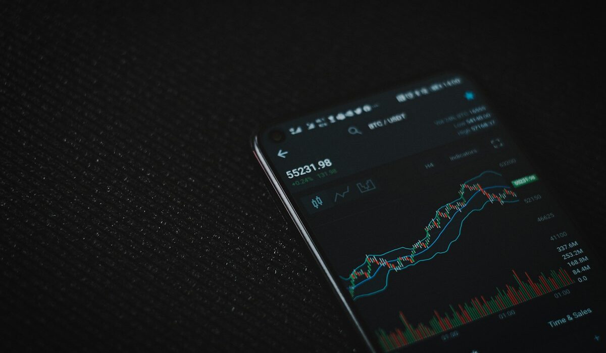 Cryptocurrency trading chart on a smartphone illustrating Coinbase asset listings
