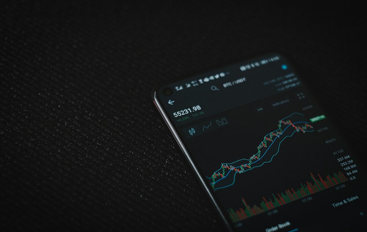 Cryptocurrency trading chart on a smartphone illustrating Coinbase asset listings