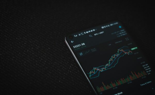 Cryptocurrency trading chart on a smartphone illustrating Coinbase asset listings
