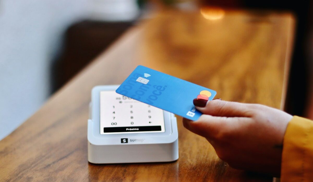 Customer holding a payment card near a contactless terminal before Mastercard earnings
