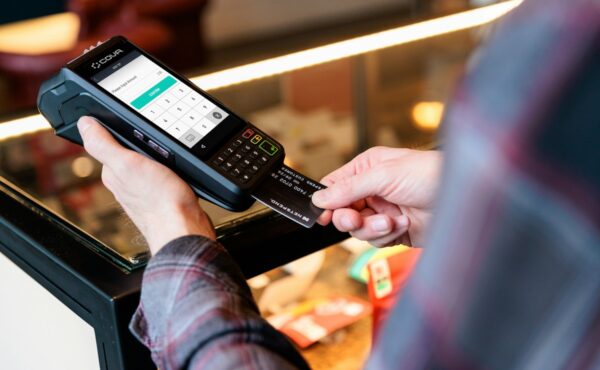 Contactless payment card held beside a digital payment terminal
