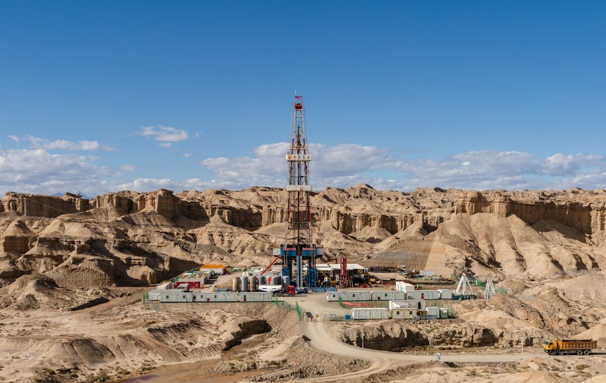 Crescent Energy offering represented by an oil drilling rig in an arid field