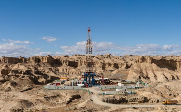 Crescent Energy offering represented by an oil drilling rig in an arid field