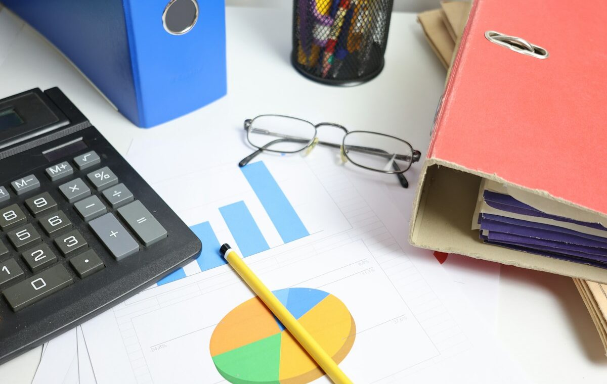 Calculator, financial charts and document folders illustrating debt-to-equity analysis. Photo by Cht Gsml on Unsplash.