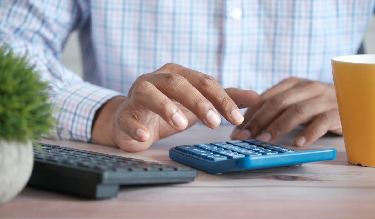 Investor using a calculator to review expense ratio costs