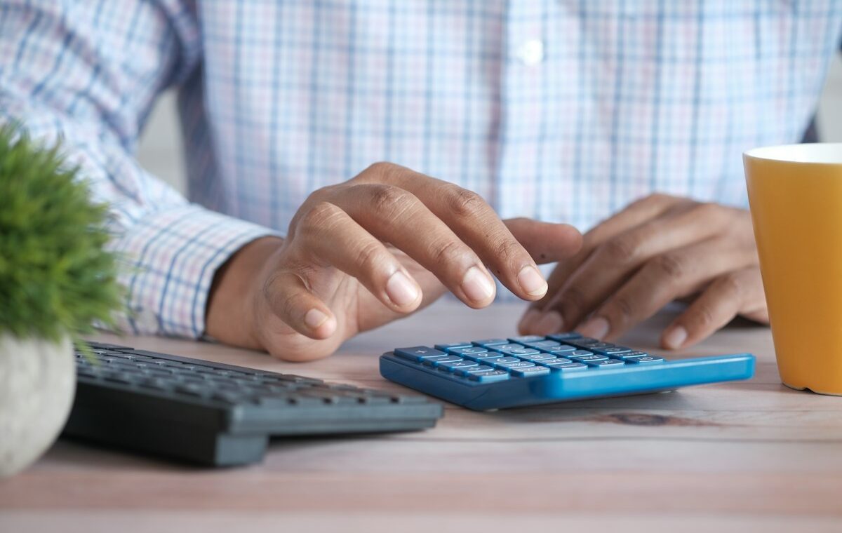 Investor using a calculator to review expense ratio costs