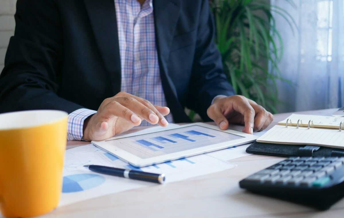 Return on equity analysis using a tablet, financial charts and calculator