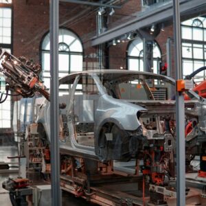 GM Q3 earnings preview image showing robotic arms working on a vehicle body