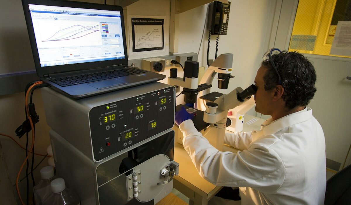Life sciences researcher using a microscope and computer for GPT-Rosalind research