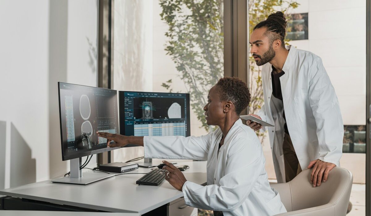 Medical specialists reviewing a brain scan on hospital monitors