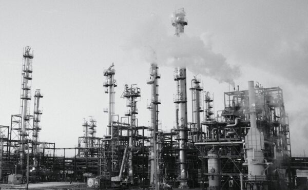 Large oil refinery complex with processing towers and industrial stacks