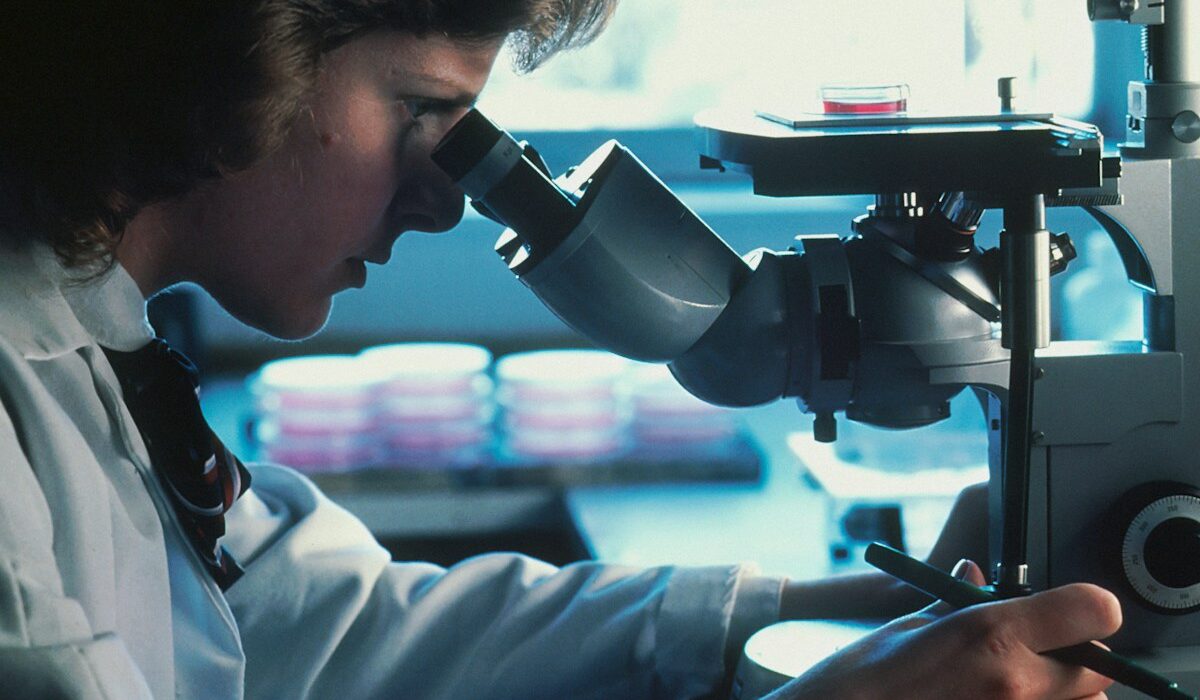 Oncology researcher using a microscope in a laboratory