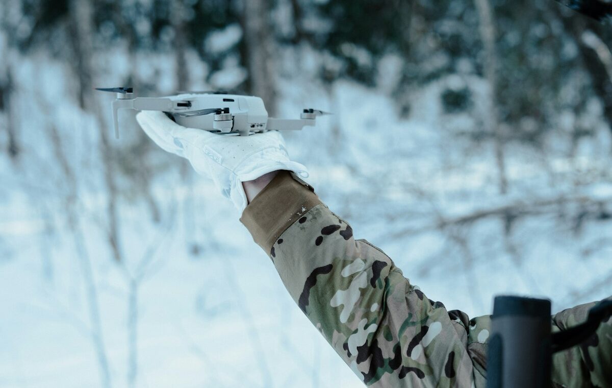 Field operator preparing a commercial drone representing Safe Pro defense AI deployments