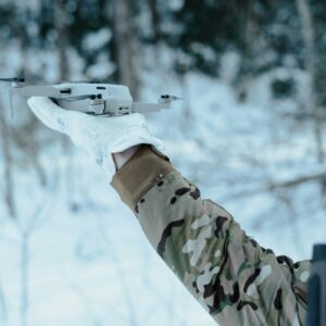 Field operator preparing a commercial drone representing Safe Pro defense AI deployments