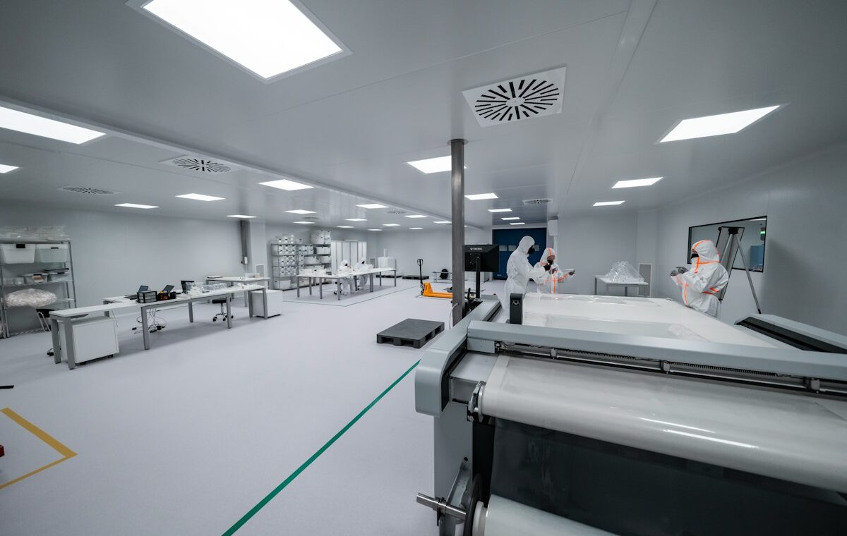 Workers in protective suits inside a semiconductor manufacturing cleanroom