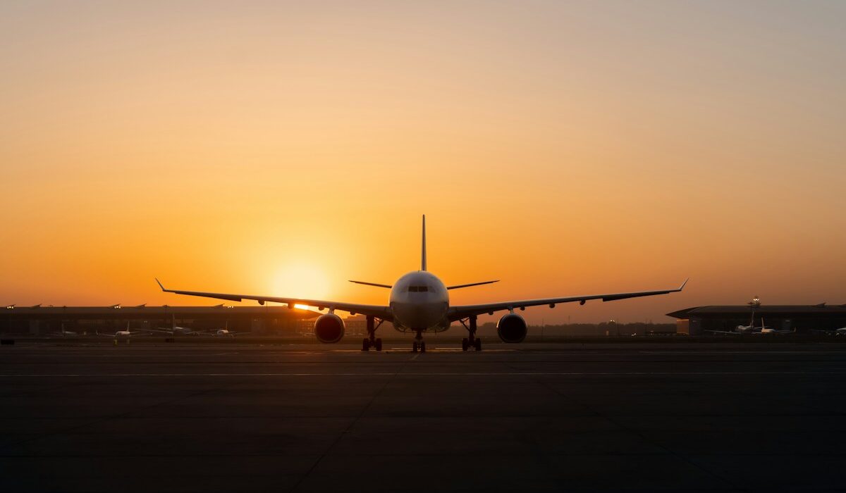 Commercial passenger aircraft positioned on an airport runway at sunset