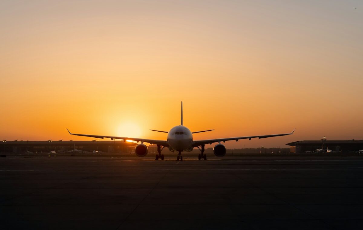 Commercial passenger aircraft positioned on an airport runway at sunset