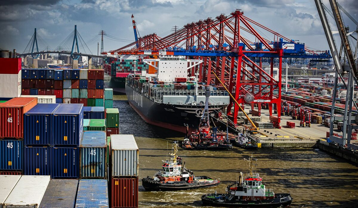 Supply chain chokepoint disruptions shown by cargo ships, cranes and containers at a busy port