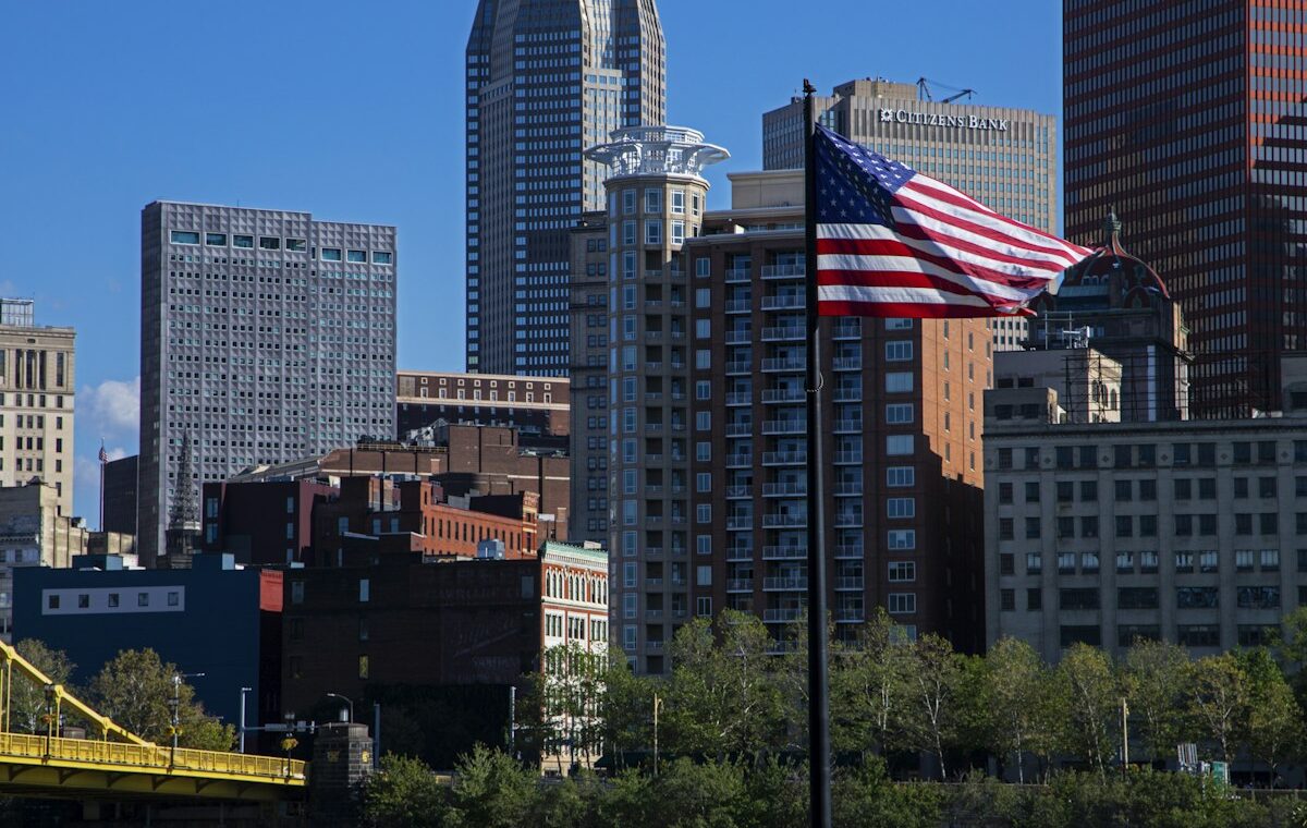 American flag before a city skyline representing the U.S. economy