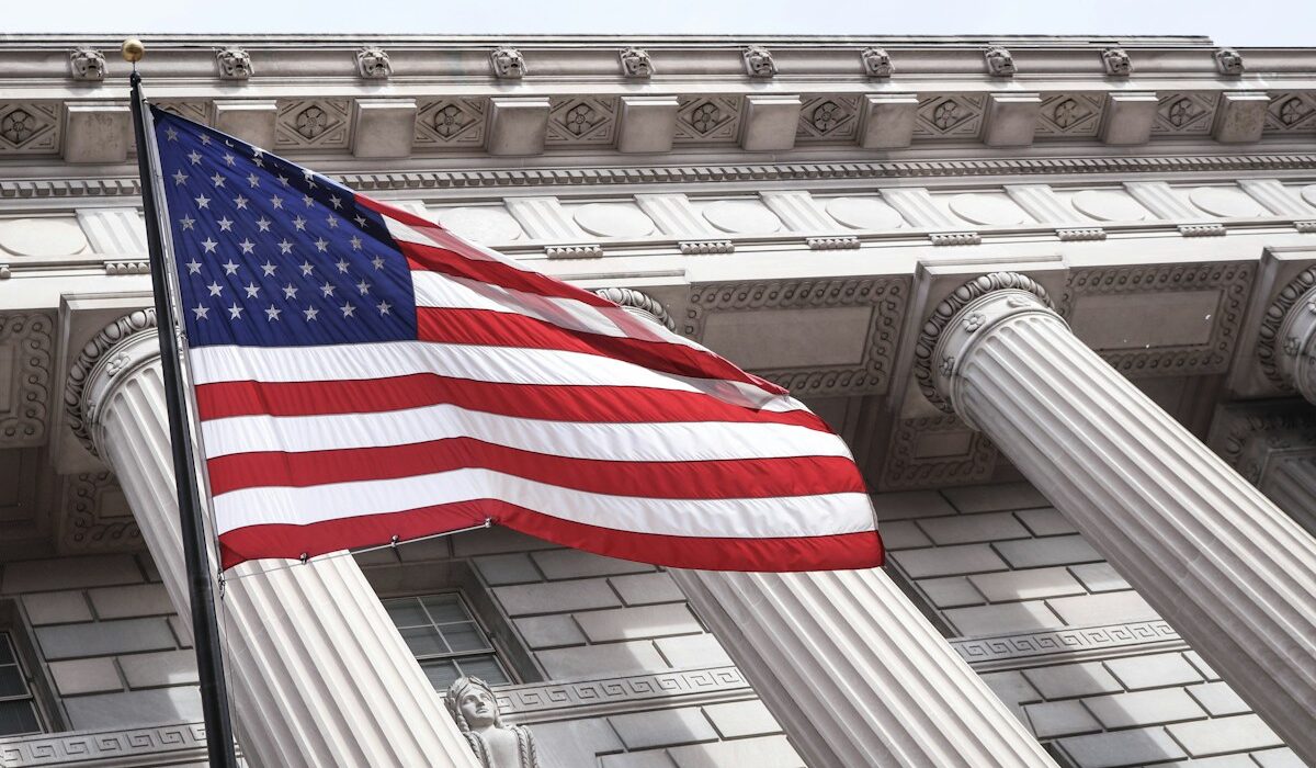 Treasury COINS Act proposal illustrated by a United States flag outside a government building