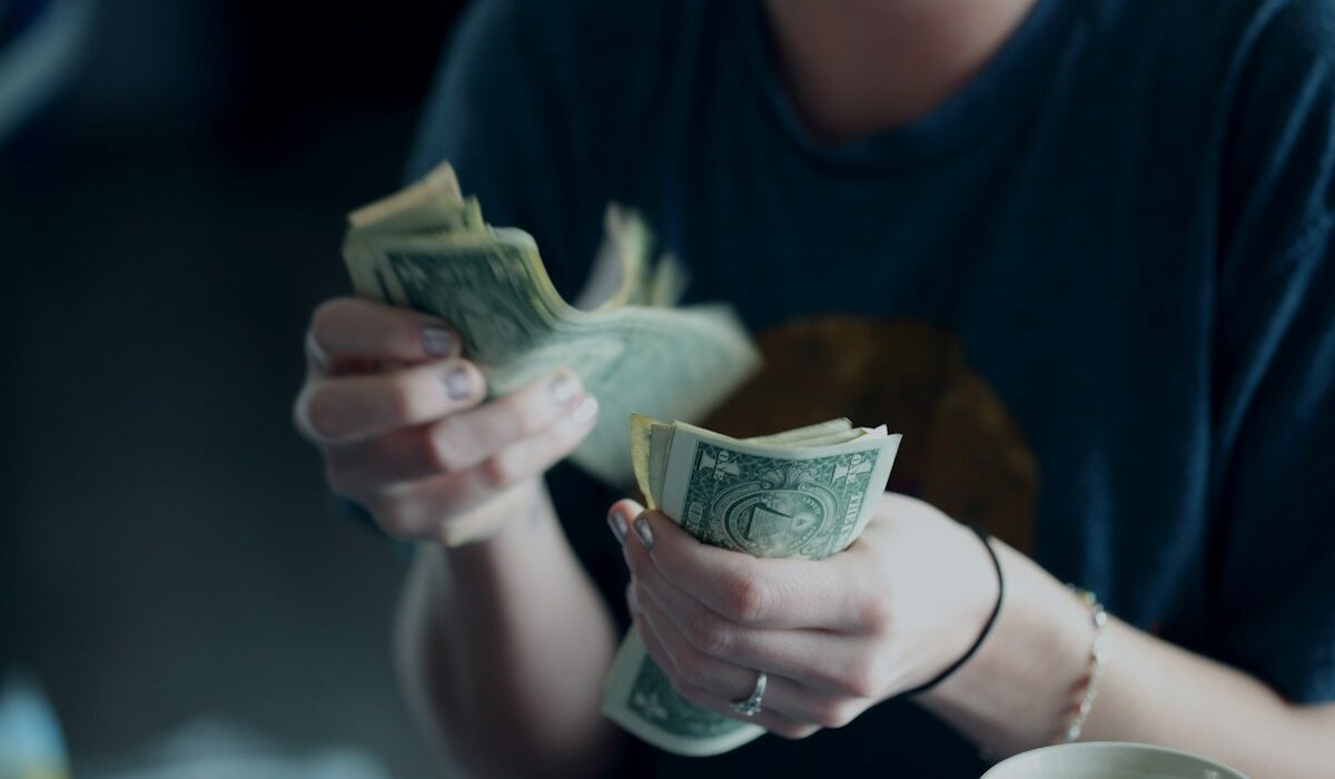 Worker counting cash as U.S. real earnings decline