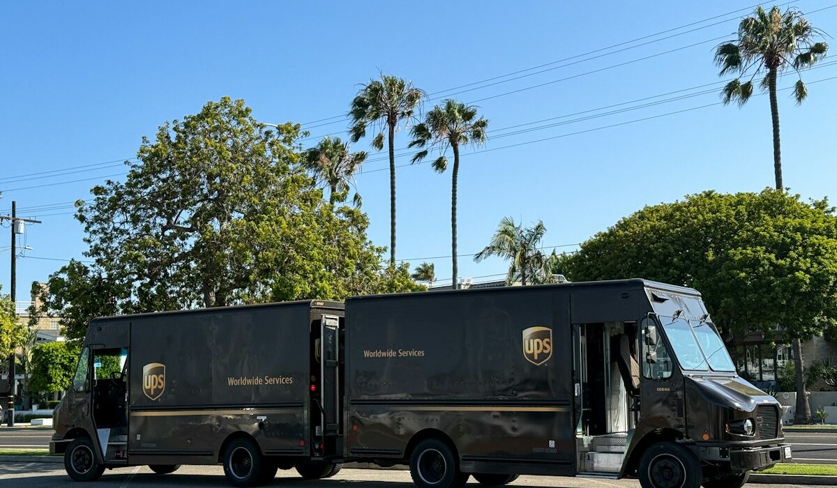Two UPS delivery trucks parked together on a city street