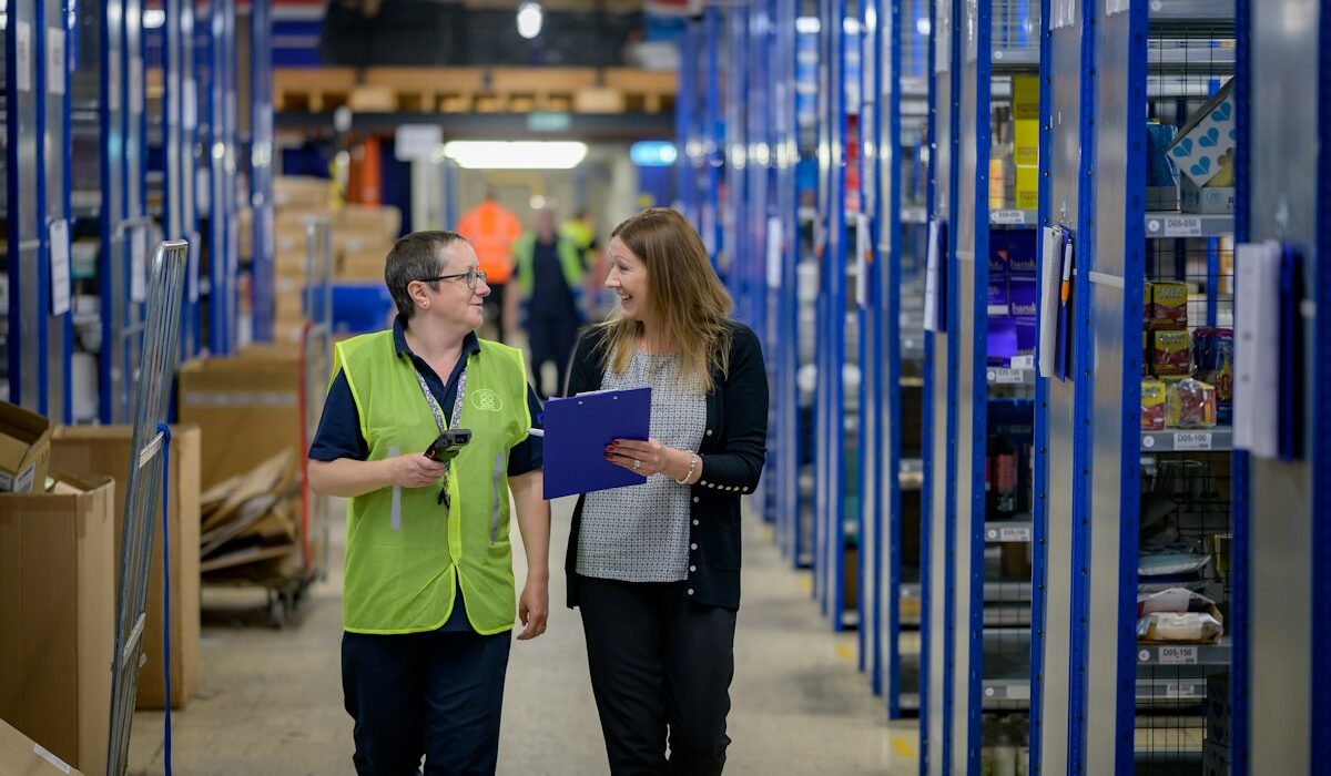 Two staff members reviewing inventory in a warehouse. Photo by Centre for Ageing Better on Unsplash.