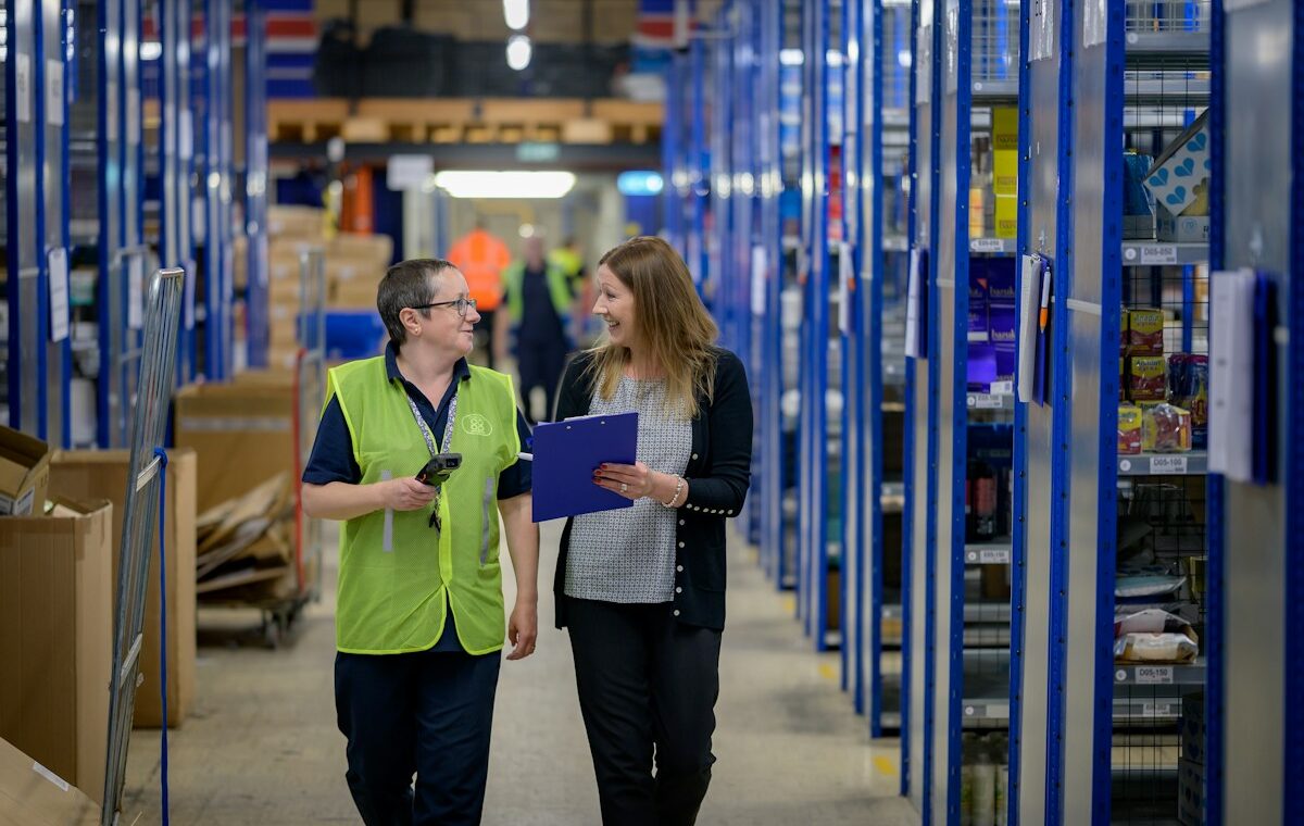Two staff members reviewing inventory in a warehouse. Photo by Centre for Ageing Better on Unsplash.